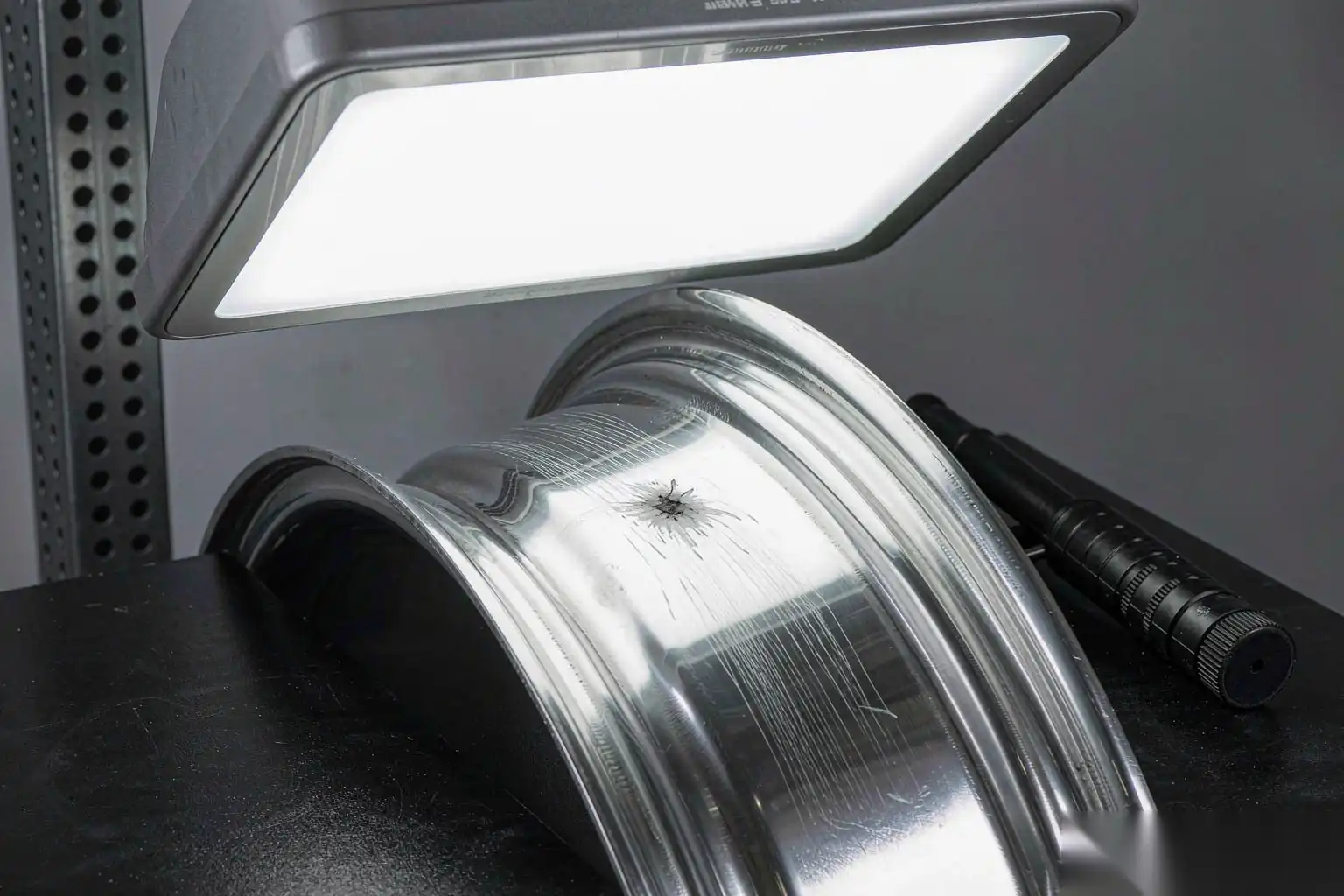 Robotic polishing head with cloth wheel finishing a stainless steel casting