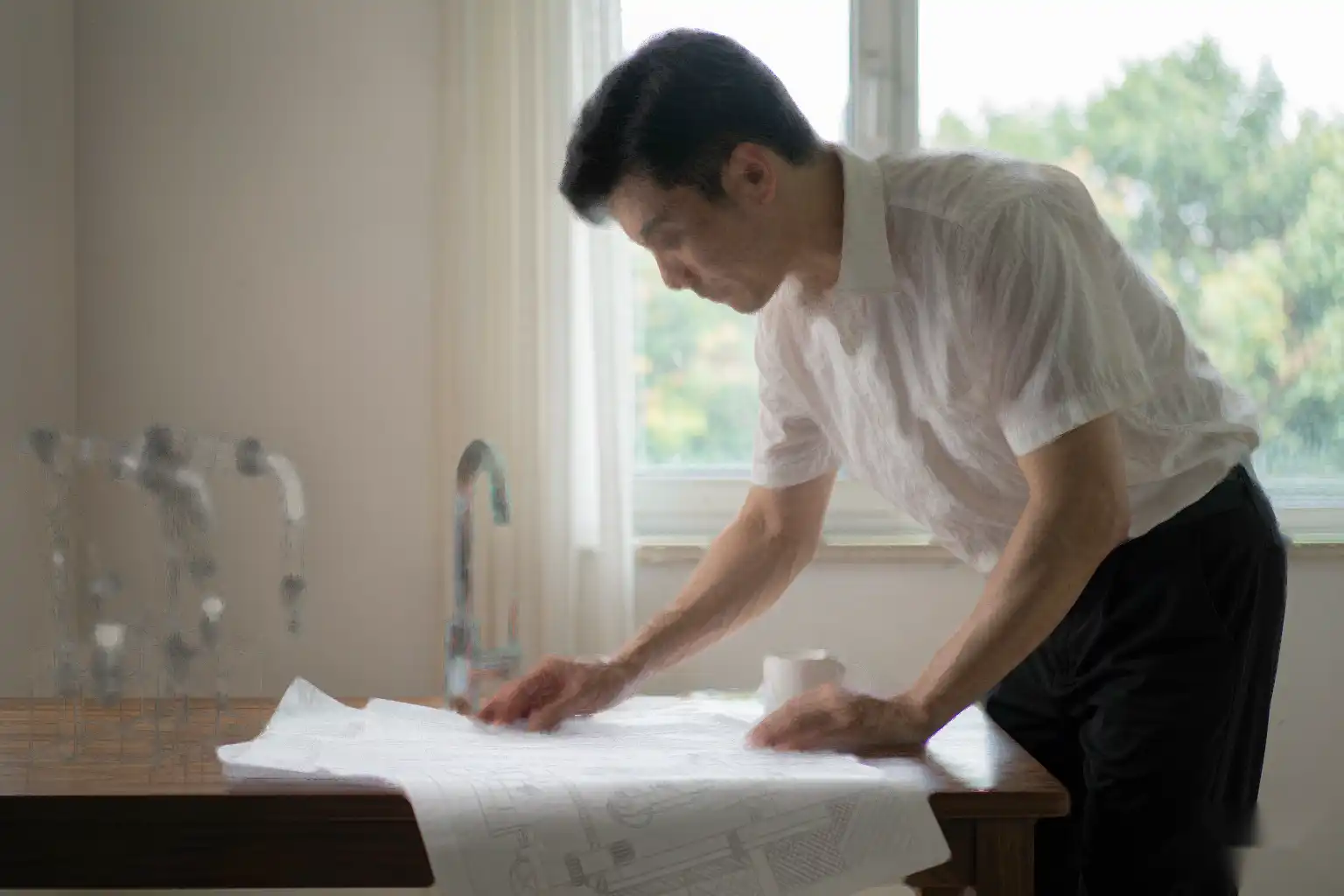 Engineer reviewing an automatic faucet production line layout with balanced stations