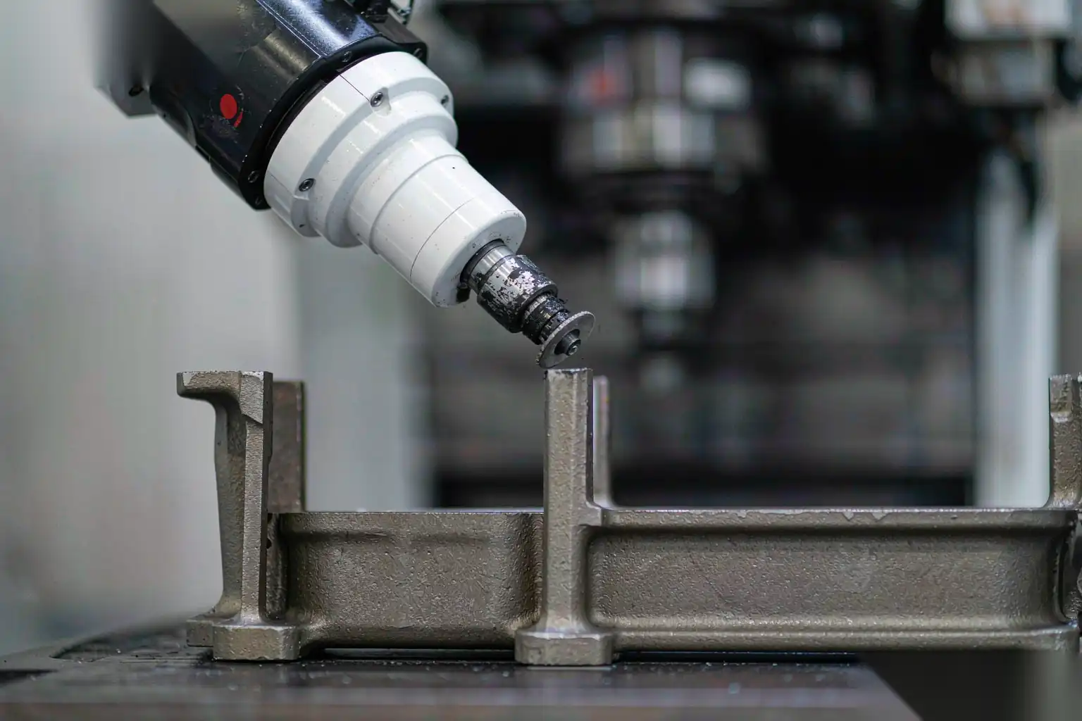 Robotic deburring spindle and tooling grinding a casting held in a fixture