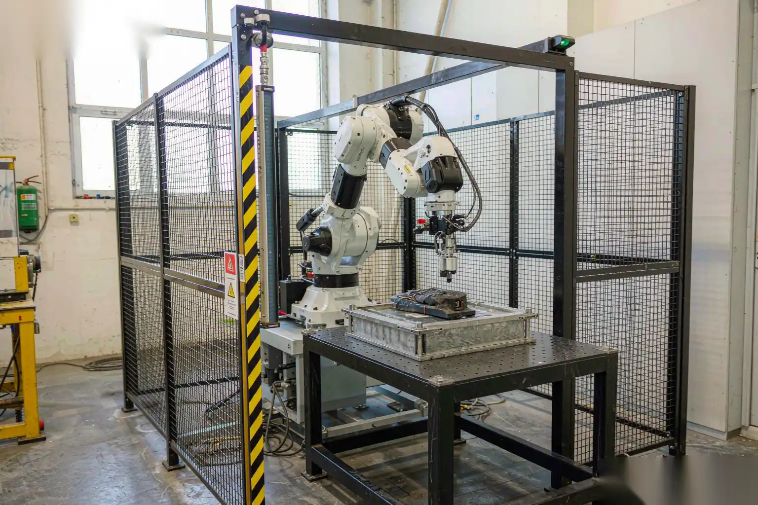 Robotic finishing cell enclosed by safety fencing and guarding